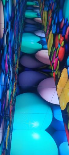 Tres paredes en las que se proyectan imágenes de globos de colores. Balloon Museum Madrid.